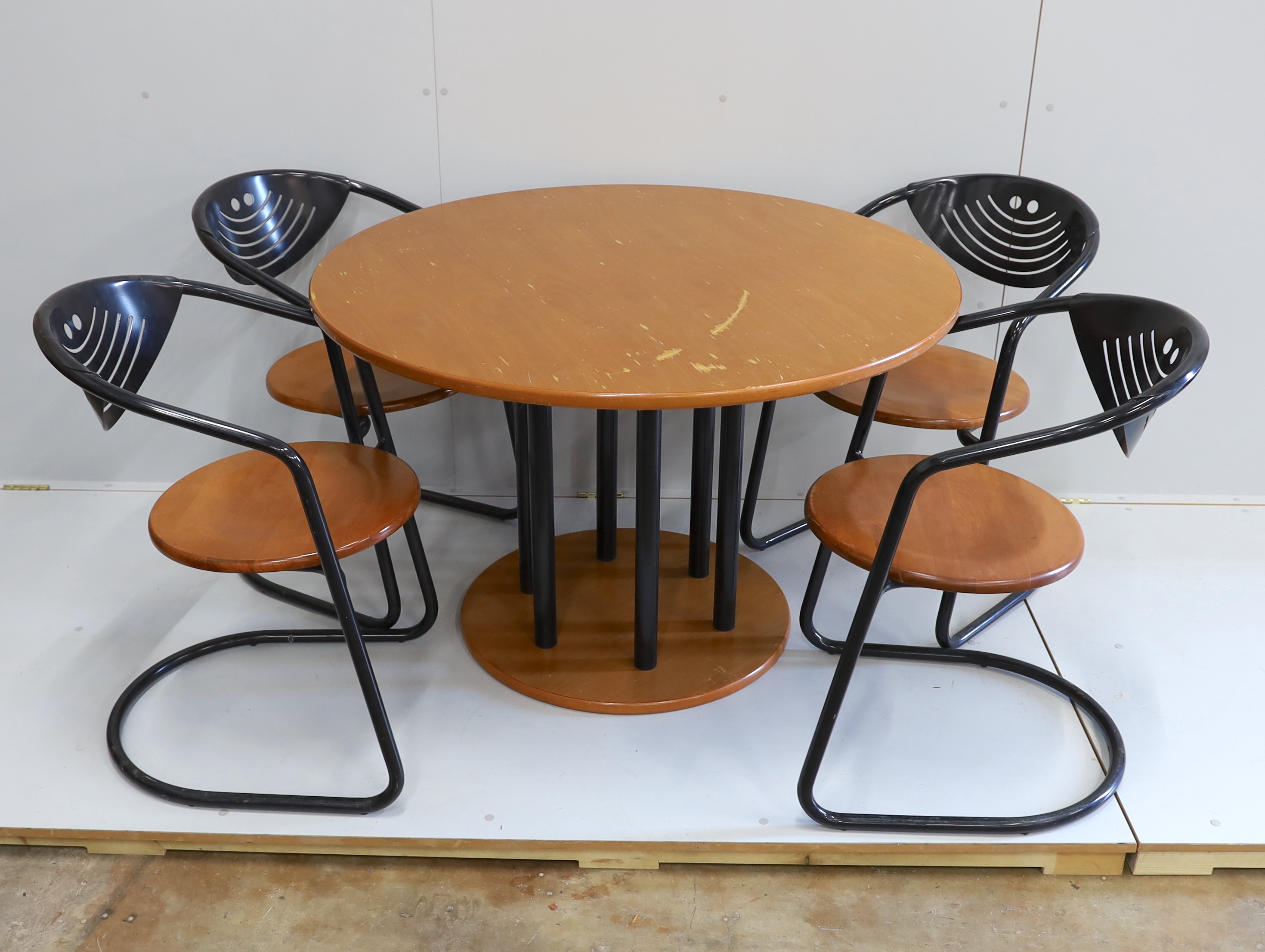 A mid century circular beech table and four cantilever chairs, table 110cm diameter, height 73cm.
